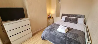 a small bedroom with a bed and a flat screen tv at A nice home in Liverpool in Liverpool