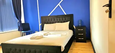 a bedroom with a bed with a blue wall at Sapphire hotel blackpool promenade in Blackpool