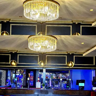 a bar with two chandeliers and a bar counter at Sapphire hotel blackpool promenade in Blackpool