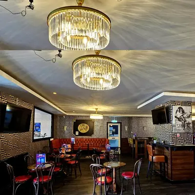 a restaurant with tables and chairs and chandeliers at Sapphire hotel blackpool promenade in Blackpool