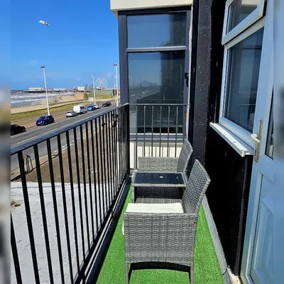 a balcony with two chairs and a door at Sapphire hotel blackpool promenade in Blackpool