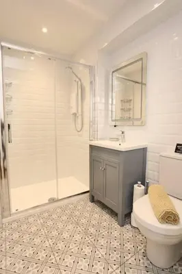 a bathroom with a shower and a toilet and a sink at Stunning Coach House with two bedrooms and parking in Hambleton