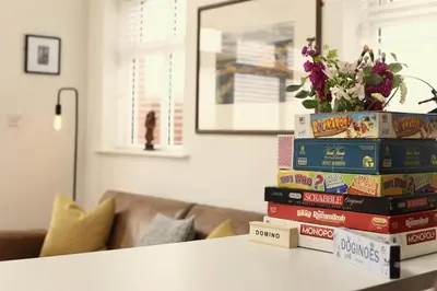 a stack of books on a table in a living room at Stunning Coach House with two bedrooms and parking in Hambleton