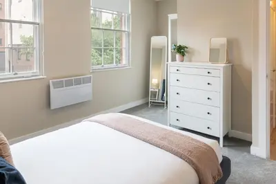 a bedroom with a bed and a dresser and windows at Host & Stay - The Quarter in Liverpool