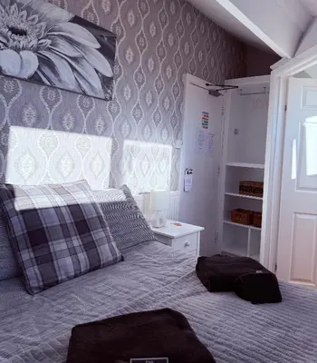 a bedroom with a bed with a pillow and a window at St Andrews house Hotel in Preston
