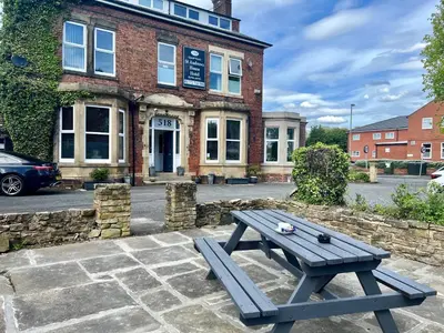 a picnic table sitting in front of a building at St Andrews house Hotel in Preston