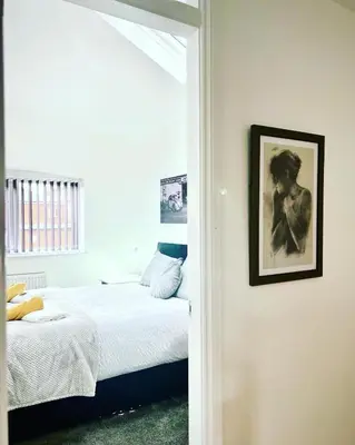 a bedroom with a bed and a picture on the wall at St Andrews house Hotel in Preston