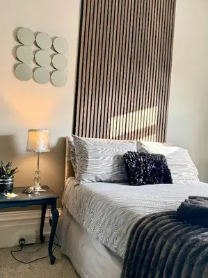a bedroom with a bed and a table with a lamp at St Andrews house Hotel in Preston