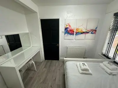 a room with a bed and a desk and a mirror at Modern Pink Cottage in Blackpool in Blackpool