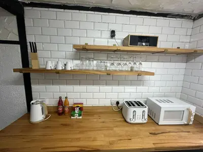 a kitchen with a counter with a toaster and a microwave at Modern Pink Cottage in Blackpool in Blackpool
