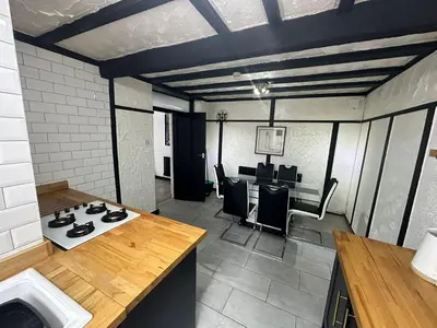 a kitchen with a stove and a table with chairs at Modern Pink Cottage in Blackpool in Blackpool