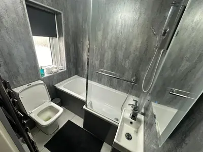 a bathroom with a shower and a toilet and a sink at Modern Pink Cottage in Blackpool in Blackpool
