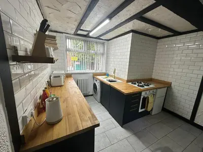 a kitchen with a sink and a stove at Modern Pink Cottage in Blackpool in Blackpool