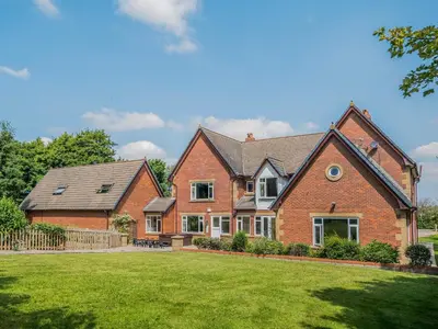 a large brick house with a grass yard at The Farmhouse At Ream Hills in Weeton