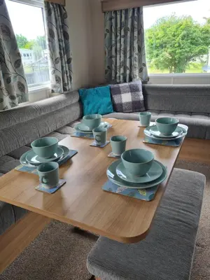 a wooden table with cups and saucers on it at The Mayflower in Millom