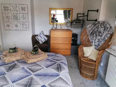 a bedroom with a bed and a chair and a mirror at Aqua View, New Brighton Beach- 2 Bedroom with BALCONY & VIEW in New Brighton