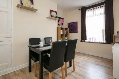 a dining room with a black table and chairs at Comfy Home King Size Bed close to Asda & Sefton Park, Very Fast WIFI! in Liverpool