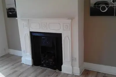 a fireplace with a white mantle in a room at Comfy Home King Size Bed close to Asda & Sefton Park, Very Fast WIFI! in Liverpool