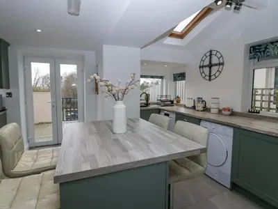 a kitchen with a table with a vase of flowers on it at Willow Cottage in Carnforth