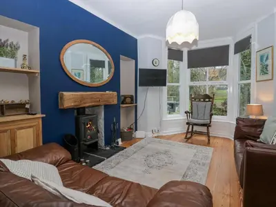 a living room with a couch and a mirror at Willow Cottage in Carnforth