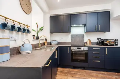 a kitchen with dark blue cabinets and a sink at The Tides, 3 bed house Morecambe in Morecambe