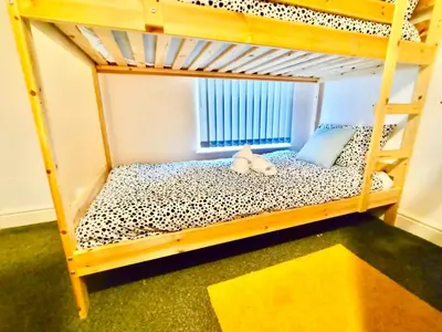 a bunk bed with a stuffed animal sitting on the bottom bunk at Liverpool 4 Bed Home Sleeps 18 Free Parking in Liverpool