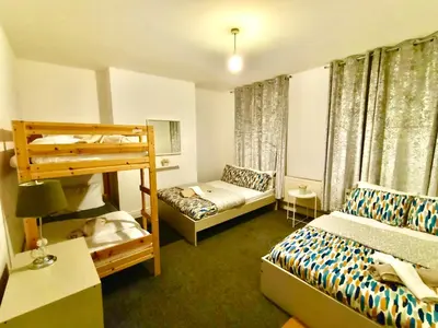 a bedroom with two beds and a bunk bed at Liverpool 4 Bed Home Sleeps 18 Free Parking in Liverpool