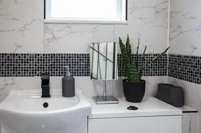 a bathroom with a sink and a potted plant at Spacious House 10min to Liverpool Centre in Wallasey