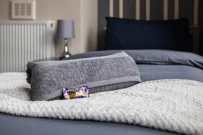a bed with two pillows on top of it at Spacious House 10min to Liverpool Centre in Wallasey