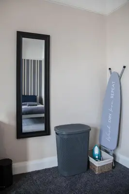 a bathroom with a trash can and a mirror at Spacious House 10min to Liverpool Centre in Wallasey