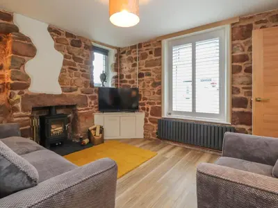 a living room with a fireplace and a tv at Woodman Cottage in Morecambe