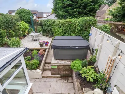 a small garden with a grill on a patio at Woodman Cottage in Morecambe