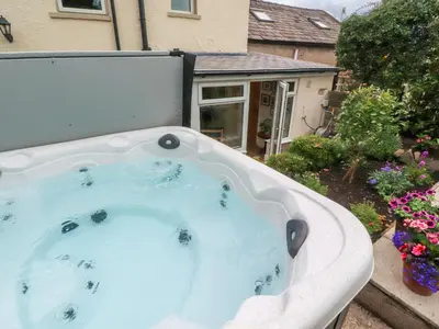 a jacuzzi tub in the backyard of a house at Woodman Cottage in Morecambe