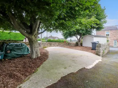 a driveway with a tree in a yard at Woodman Cottage in Morecambe