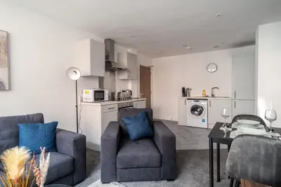 a living room with two chairs and a table at Central Preston Modern 1 Bedroom Apartment in Preston