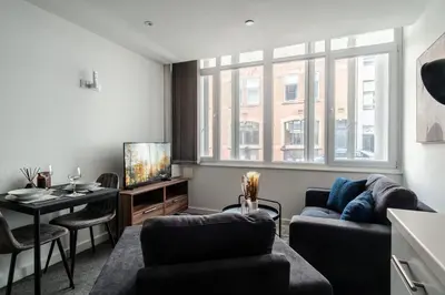 a living room with a couch and a table and a tv at Central Preston Modern 1 Bedroom Apartment in Preston