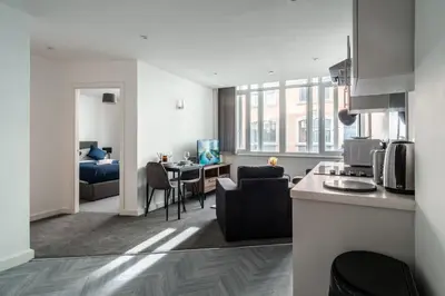 a kitchen and a living room with a table at Central Preston Modern 1 Bedroom Apartment in Preston