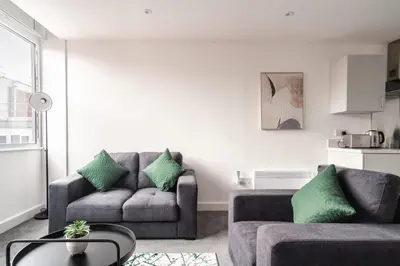 a living room with two couches and a table at 1 Bed Modern Central Preston Apartment in Preston