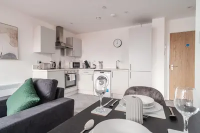 a living room with a couch and a table with wine glasses at 1 Bed Modern Central Preston Apartment in Preston