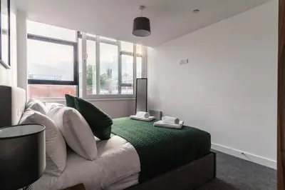 a bedroom with a bed with green and white pillows at 1 Bed Modern Central Preston Apartment in Preston