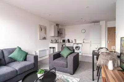 a living room with two couches and a table at 1 Bed Modern Central Preston Apartment in Preston