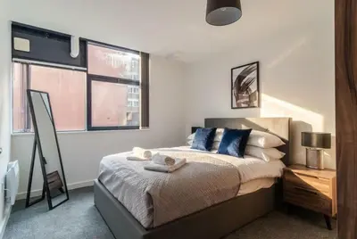 a bedroom with a bed and two windows at Fantastic 1 Bed Central Preston Apartment in Preston
