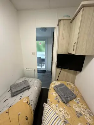 two beds in a small room with a tv at Elite Retreat Blackpool in Blackpool