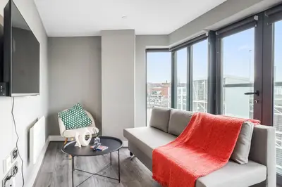 a living room with a couch and a table at Waterfront Luxury Apartment in Liverpool