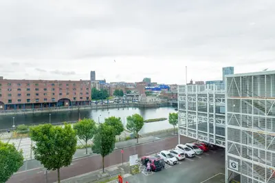 a view of a city with cars parked in a parking lot at Waterfront Luxury Apartment in Liverpool