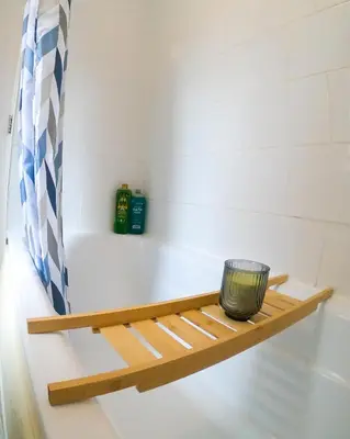a bathroom with a wooden shelf next to a bath tub at Miles Home Anfield-Liverpool in Liverpool