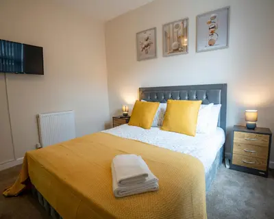 a bedroom with a large bed with yellow pillows at Miles Home Anfield-Liverpool in Liverpool