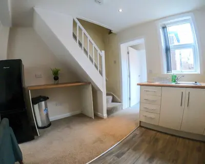a kitchen with a staircase with a sink and a counter at Miles Home Anfield-Liverpool in Liverpool