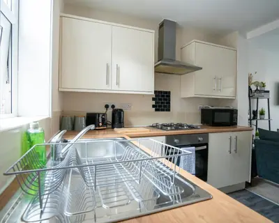 a kitchen with a dish rack in the sink at Miles Home Anfield-Liverpool in Liverpool