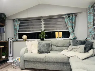 a living room with a couch and a window at Vinchella-3 bedroom caravan in Grange Over Sands
